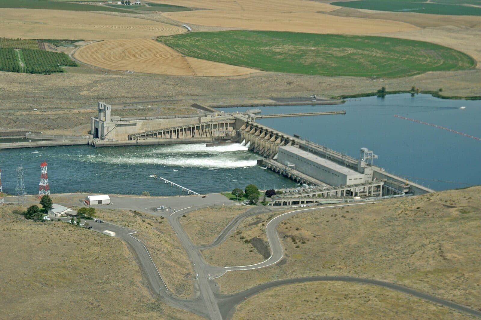 One of the Lower Snake River dams with rail lines and highway traffic along the riverbank